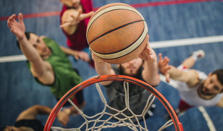 High angle view of basketball player slam dunking the ball during the game.